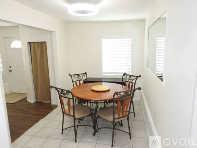 A dining room with a round table and chairs.