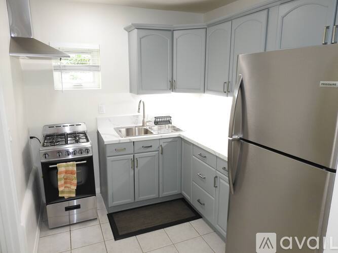 A kitchen with a stove, sink, and refrigerator.