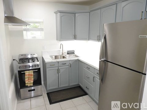 A kitchen with a stove, sink, and refrigerator.