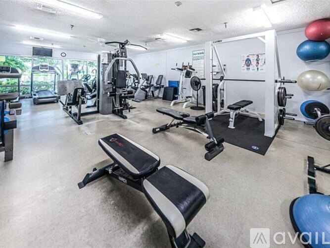 A gym with a variety of equipment including weights and cardio machines.