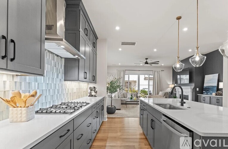 A modern kitchen with a white countertop and grey cabinets.