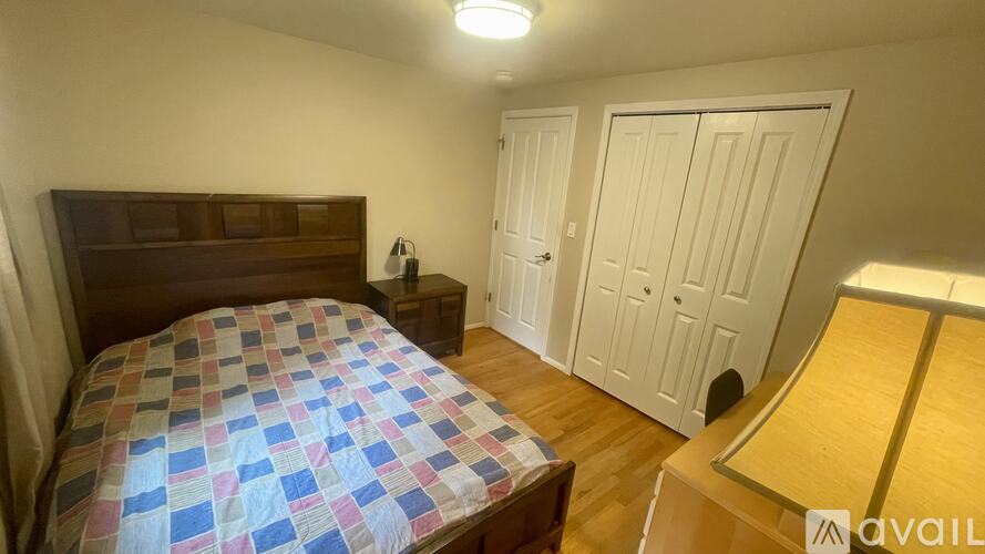 A bedroom with a bed, a nightstand, and a wardrobe.