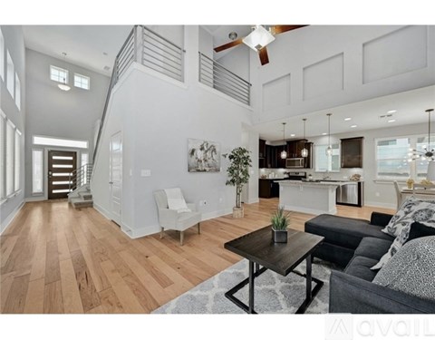 A living room with a black couch and a wooden coffee table.