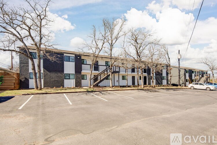 A parking lot in front of a building with a car parked.