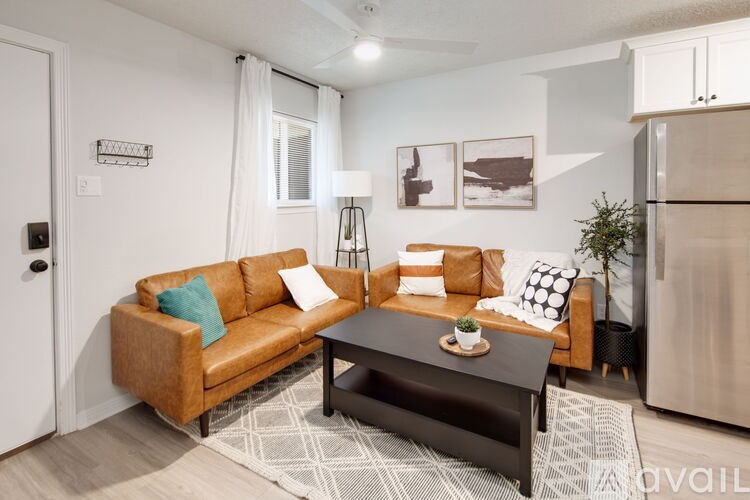 A living room with a brown couch and a black coffee table.