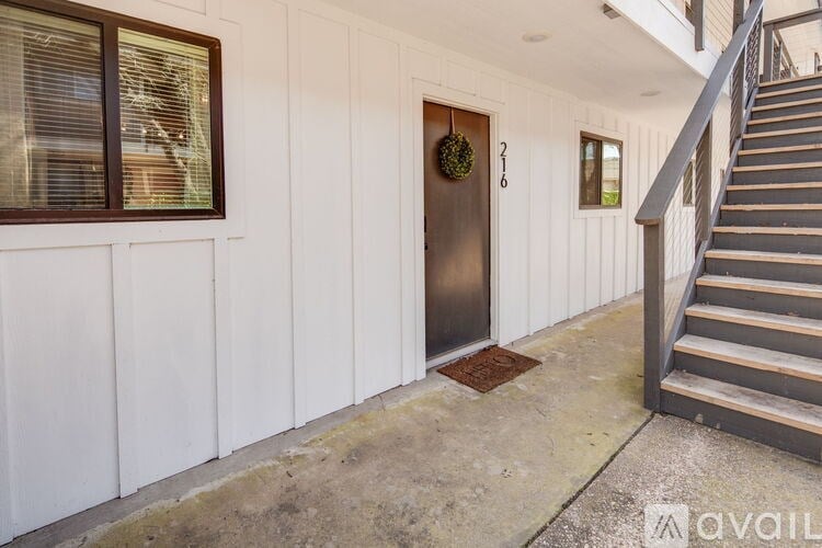 A white building with a brown door and a wreath on it.