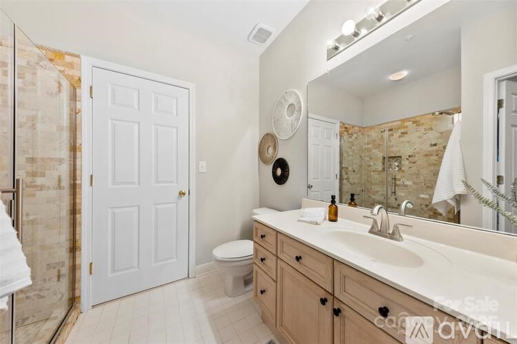 A bathroom with a toilet, sink, and mirror.