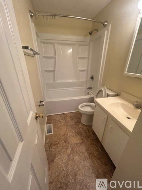 A bathroom with a toilet, sink, and bathtub.
