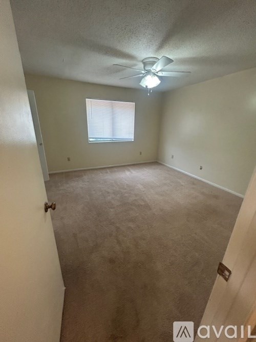 A room with a ceiling fan and a window.