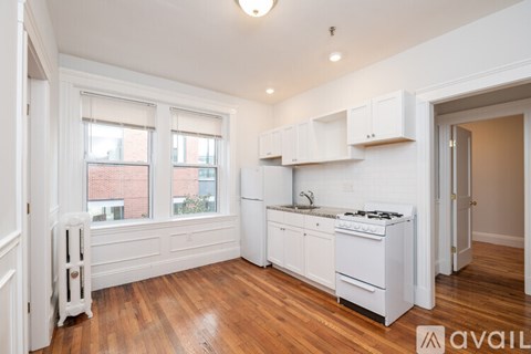 A kitchen with white cabinets and a stove top oven.