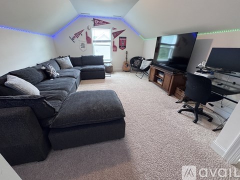 A living room with a grey couch and a television.