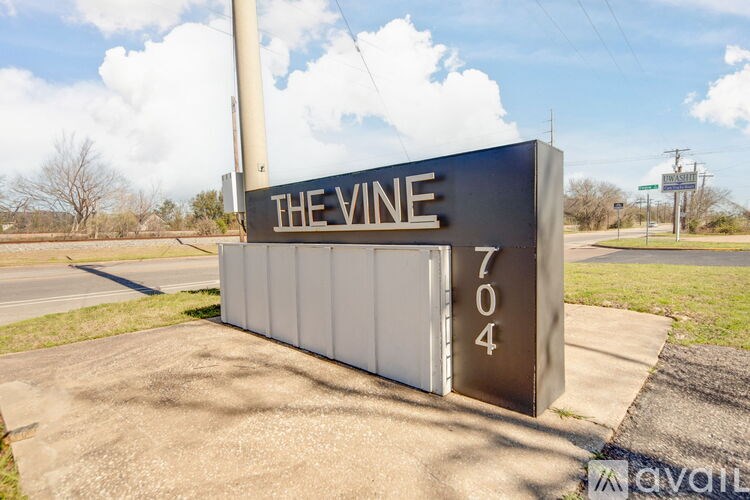 A sign for The Vine 704 is displayed in front of a grassy area.