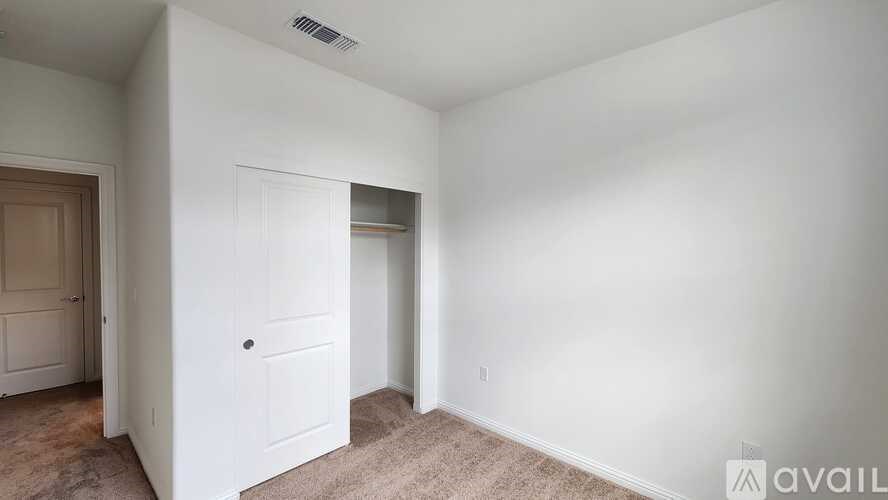 A room with a door and a carpeted floor.