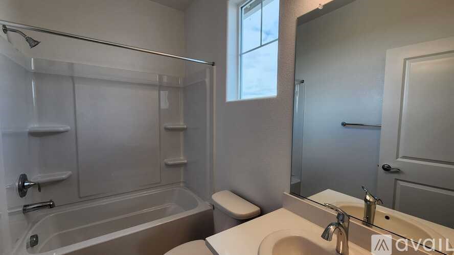 A bathroom with a tub, toilet, and sink.