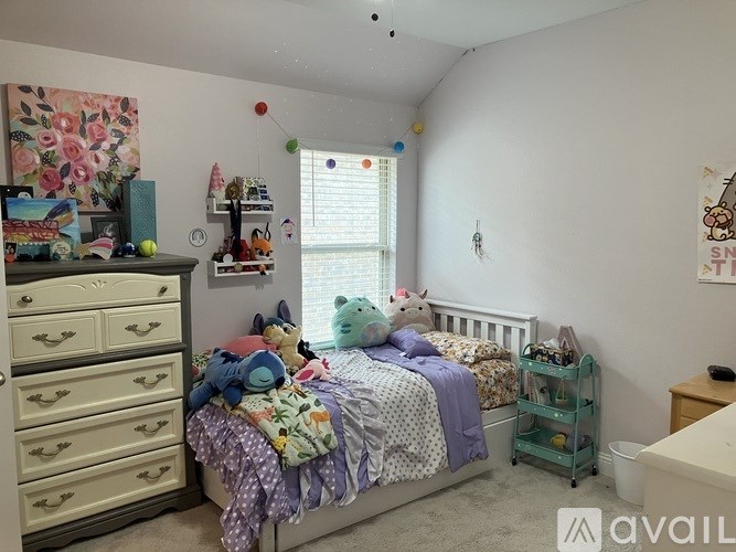 A child's bedroom with a bed, dresser, and toys.