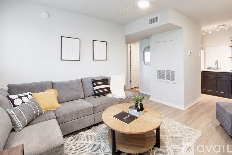 A living room with a grey couch and a coffee table.