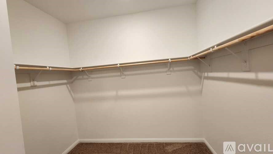 Empty room with white walls and a brown carpet.