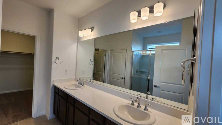 A bathroom with a sink, mirror, and lights.