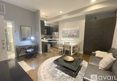 A modern living room with a black coffee table in the center.
