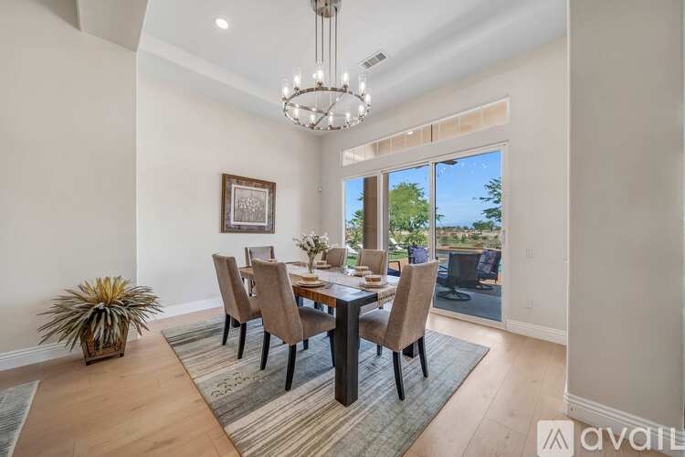 A dining room with a table set for six and a view of the backyard.