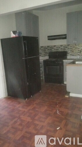 A kitchen with a black refrigerator and a black stove top oven.