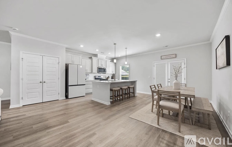 A kitchen with a dining table and chairs in the middle of the room.