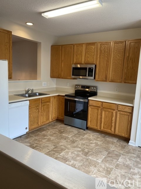 A kitchen with wooden cabinets and a tiled floor.