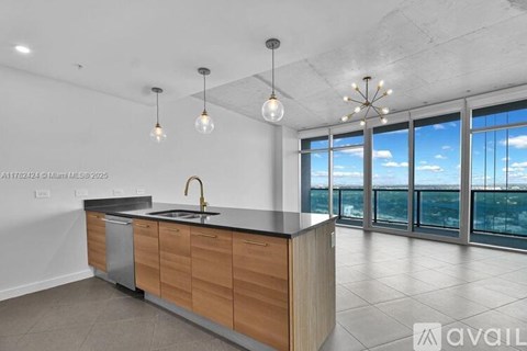 A modern kitchen with wooden cabinets and a large window overlooking the city.