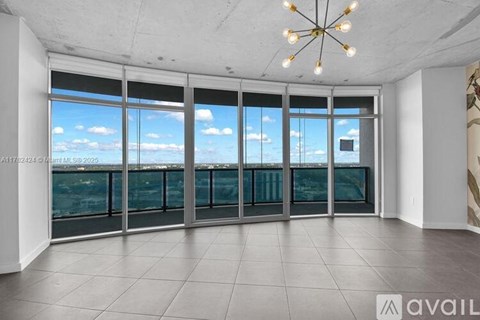 A room with a large window overlooking a cityscape.