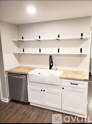 A white kitchen with a sink and a dishwasher.
