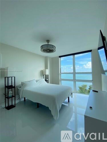 A bedroom with a large bed and a view of the ocean.
