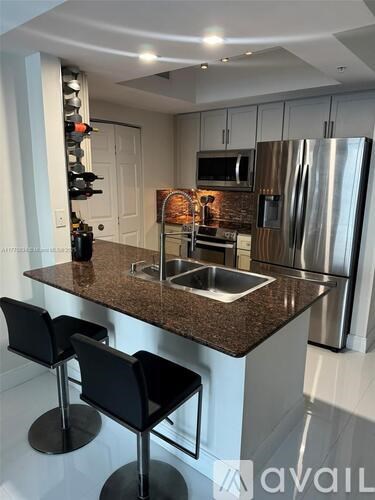 A kitchen with a granite countertop and stainless steel appliances.
