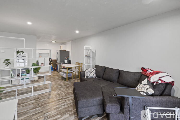 A living room with a grey couch and a wooden floor.