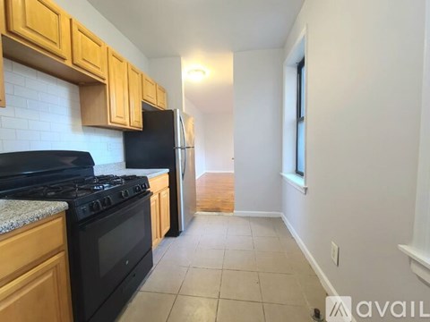 A kitchen with black appliances and wooden cabinets.