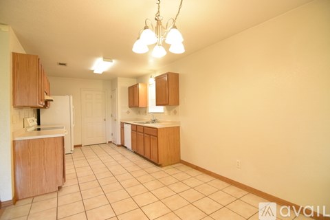 A kitchen with wooden cabinets and a tiled floor.