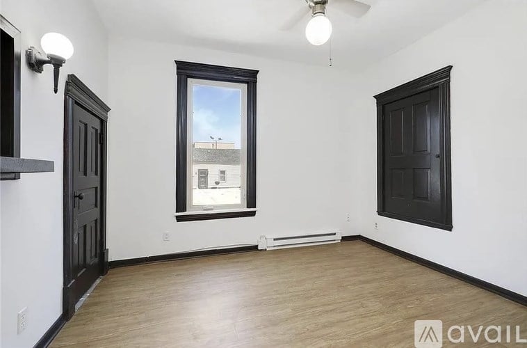 A room with a window and a ceiling fan.
