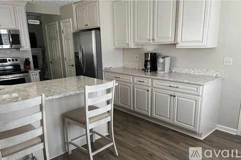 A kitchen with white cabinets and a granite countertop.