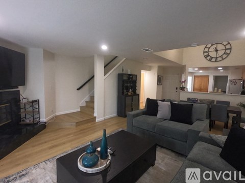 A living room with a grey couch and a fireplace.