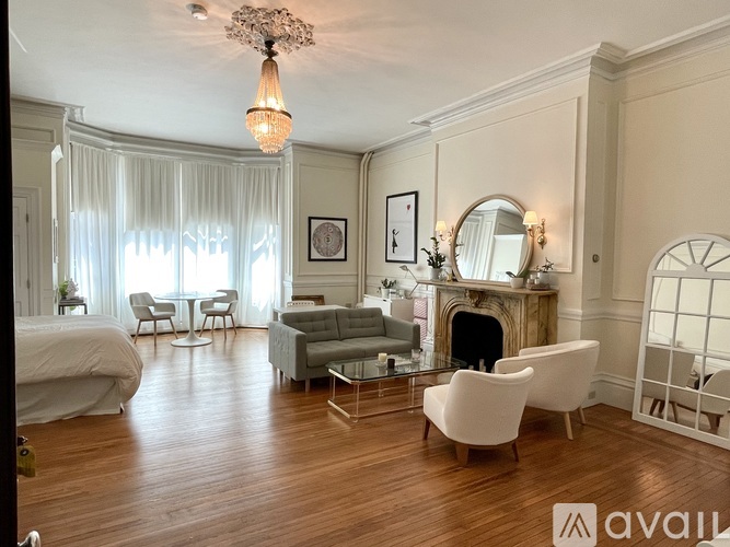 A well-lit, spacious bedroom with a fireplace and a large bed.