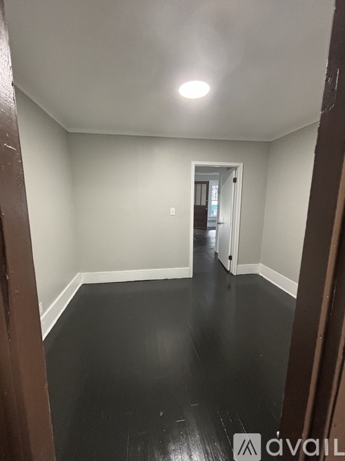 A hallway with a black floor and white walls.