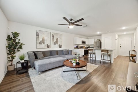 A living room with a grey couch and a coffee table in the middle.