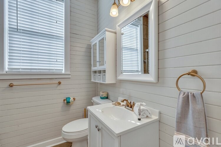 A bathroom with a white toilet, sink, and a mirror.