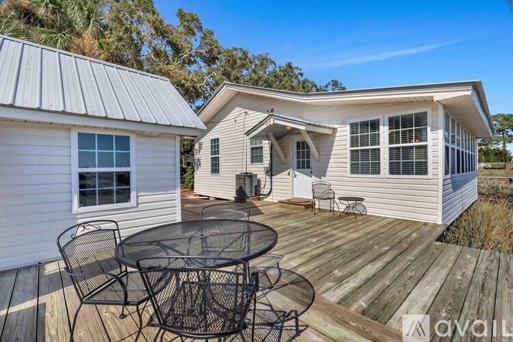 A house with a patio and a table set up for four people.