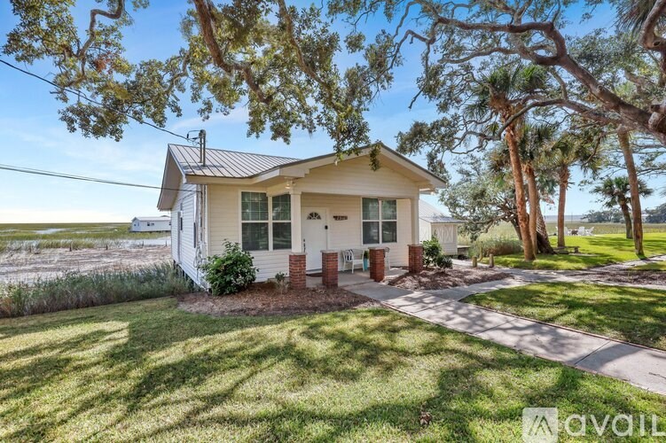 A house with a front yard and trees in the background.