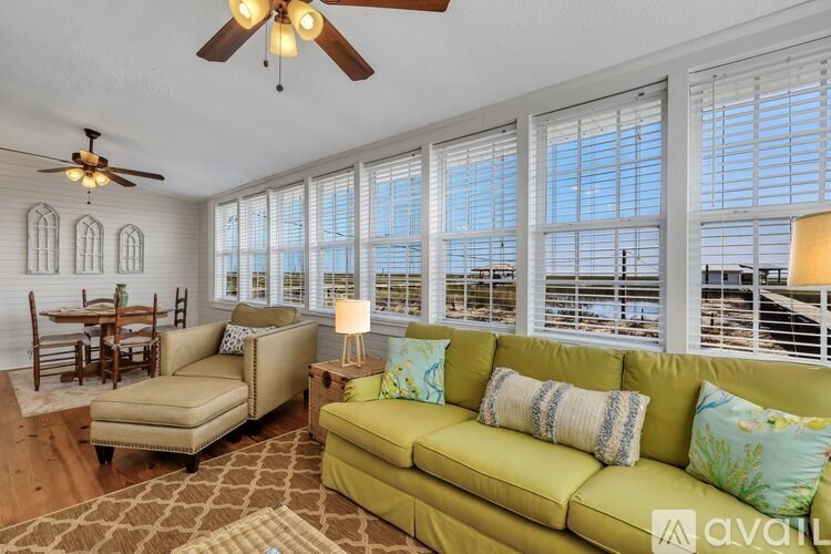 A living room with a green couch and a fan.