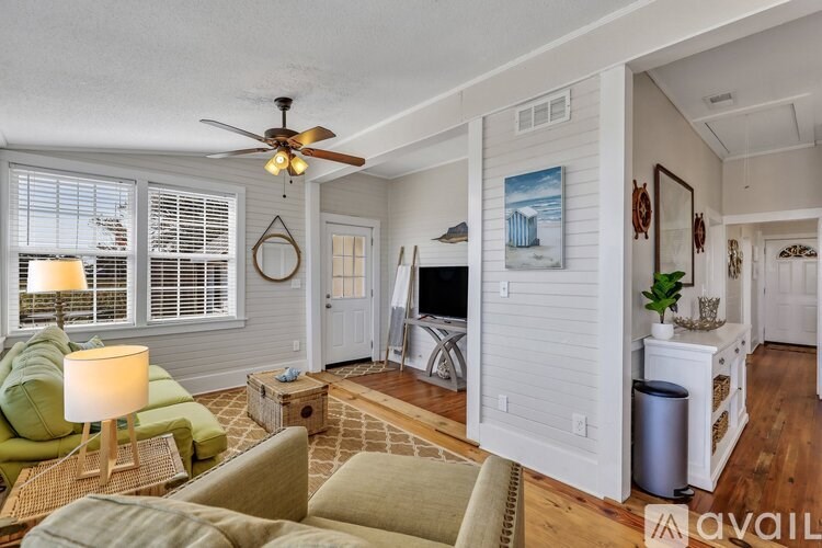 A living room with a green couch and a fan.