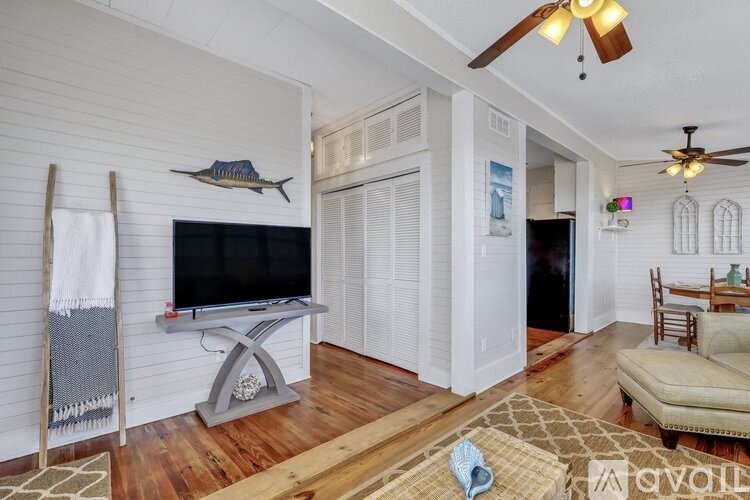 A living room with a television, a chair, and a rug.