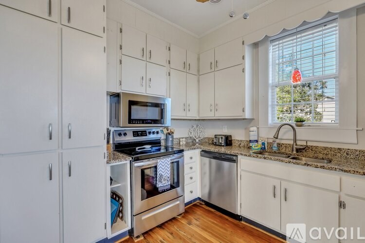 A kitchen with white cabinets and a stainless steel oven.