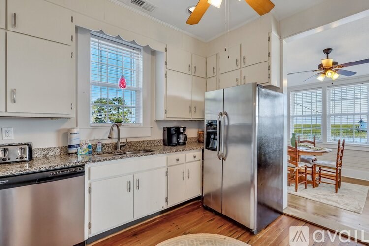 A kitchen with a refrigerator, sink, and cabinets.