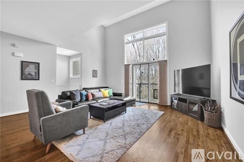 A living room with a grey sofa and a grey armchair.